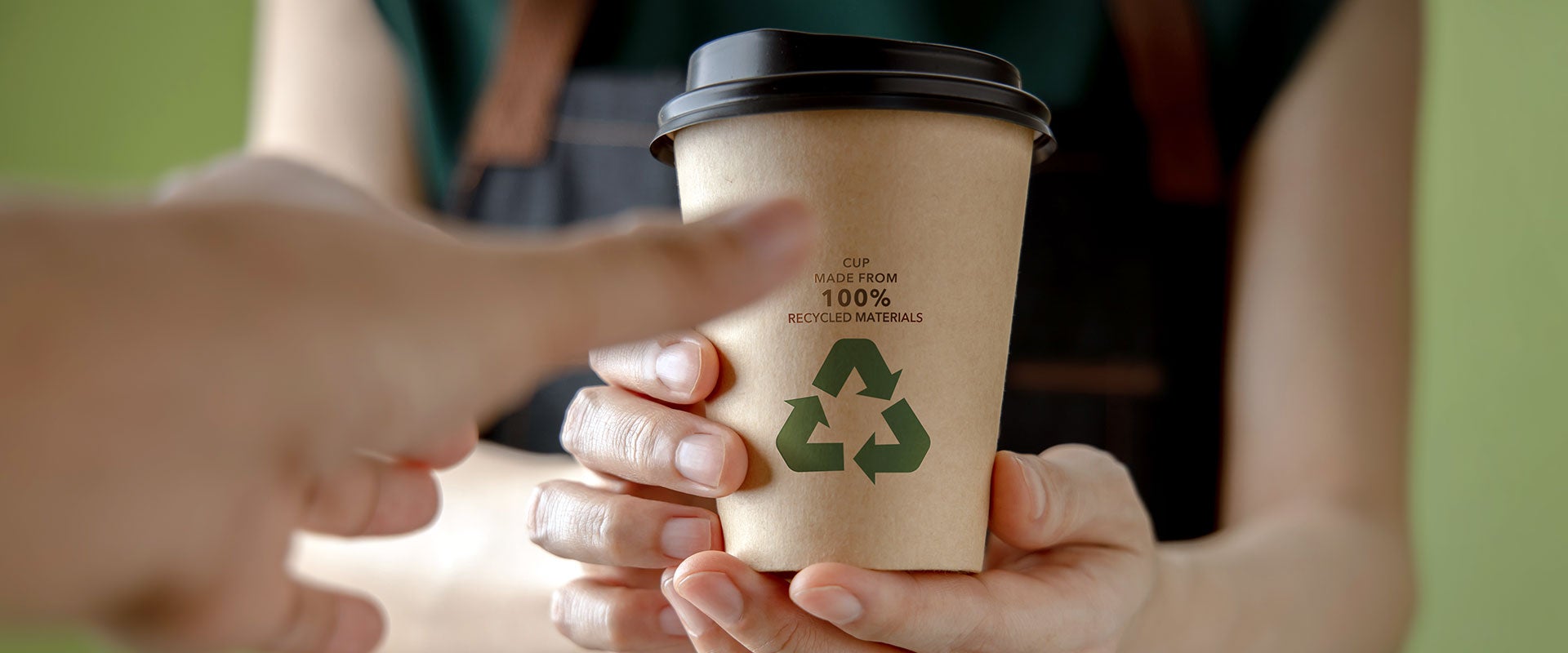 people holding recyclable coffee cup