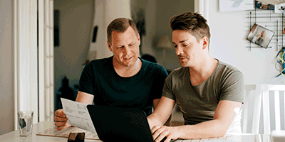 two people reading on laptop