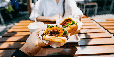 people holding burgers