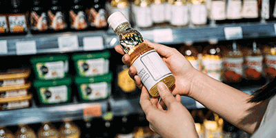 person holding bottle off shelf