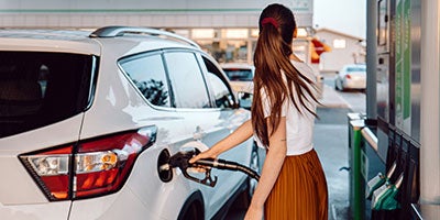 woman pumping gas into car