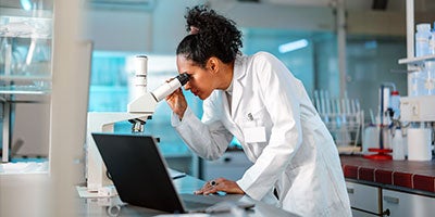 Researcher looking into microscope