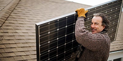 man holding solar panels