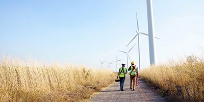 two people walking through field 