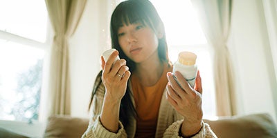 woman holding pill bottles