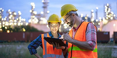 two industrial workers reading tablet