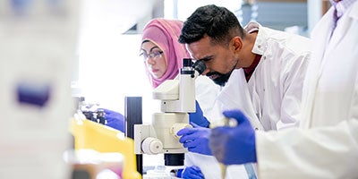 scientist looking in microscope