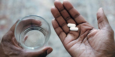 hands holding water and pills