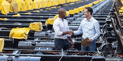 two people shaking hands in factory