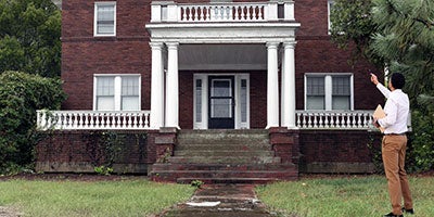 man pointing at house