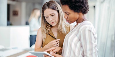 two women looking at tablet