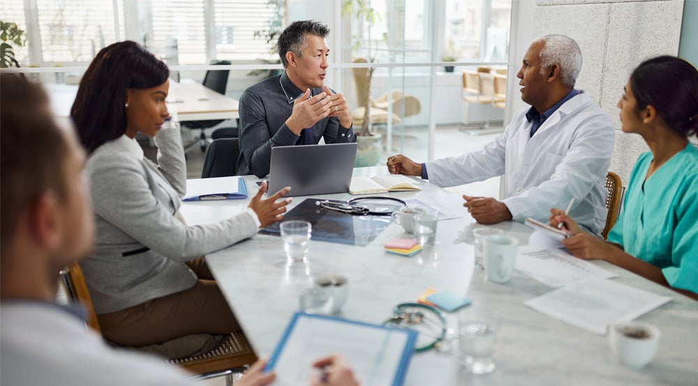 A group of medical professionals sitting in a meeting