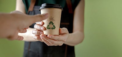 Woman holding recyclable coffee cup