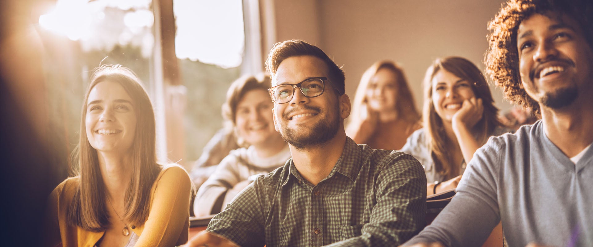 A classroom of young adult students smiling
