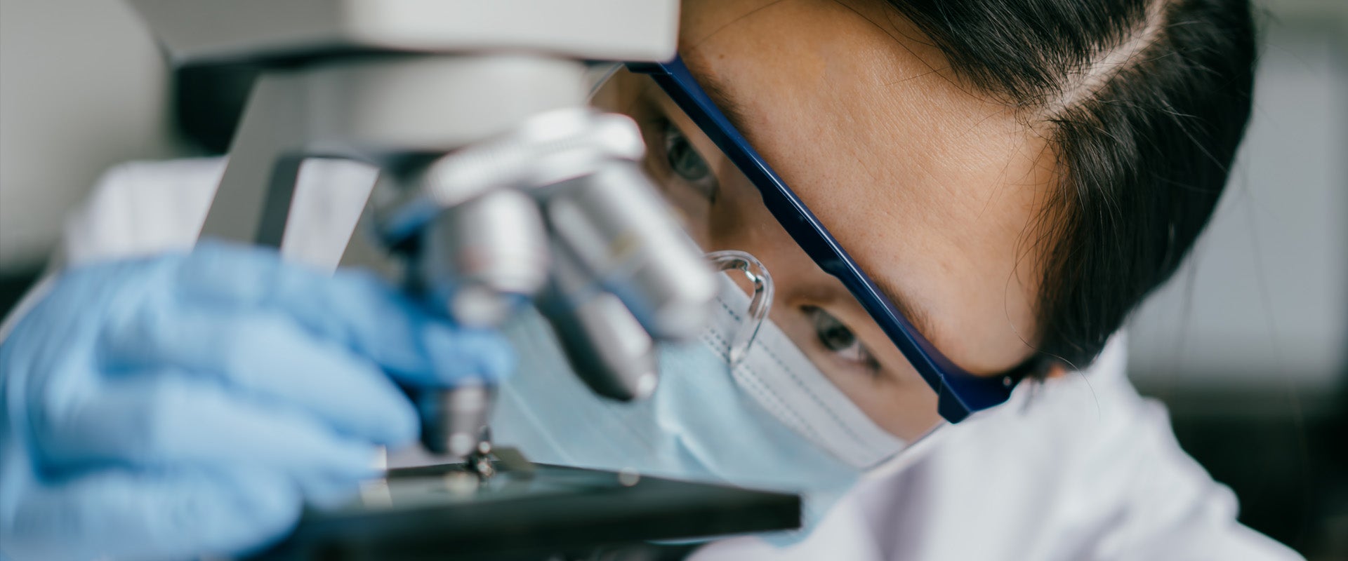Researcher looking at microscope