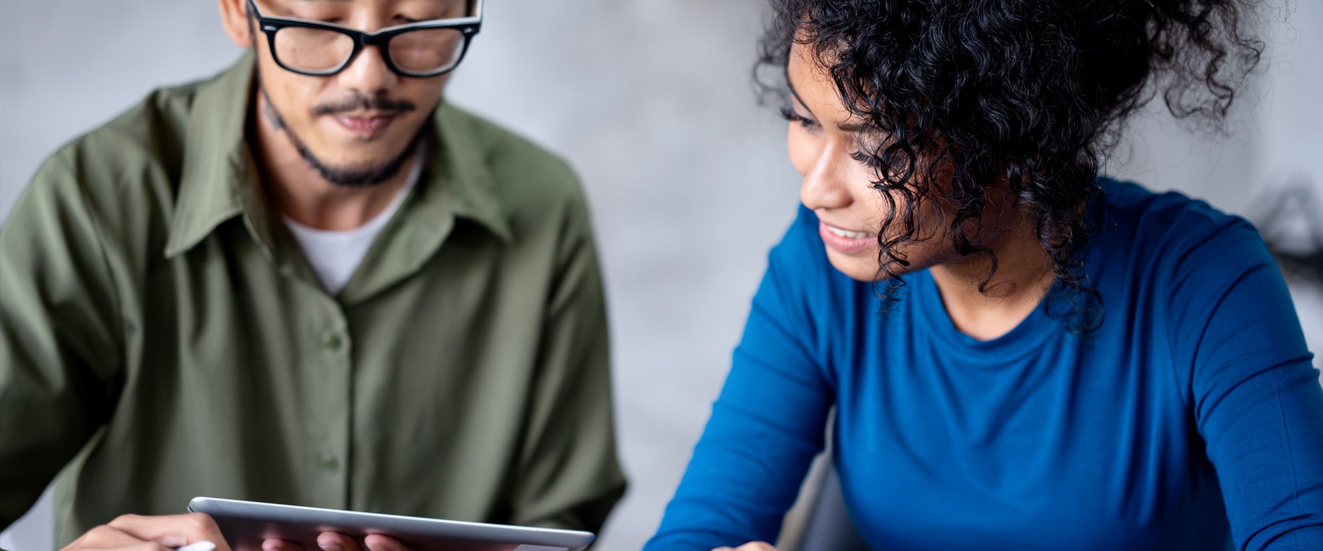 Two people looking at an on a tablet