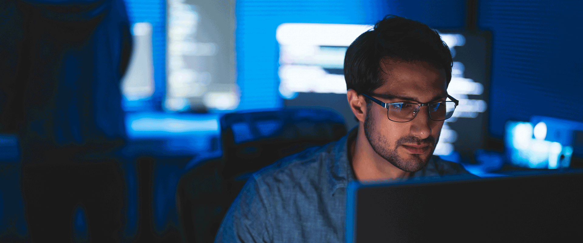 man using laptop in dark room 