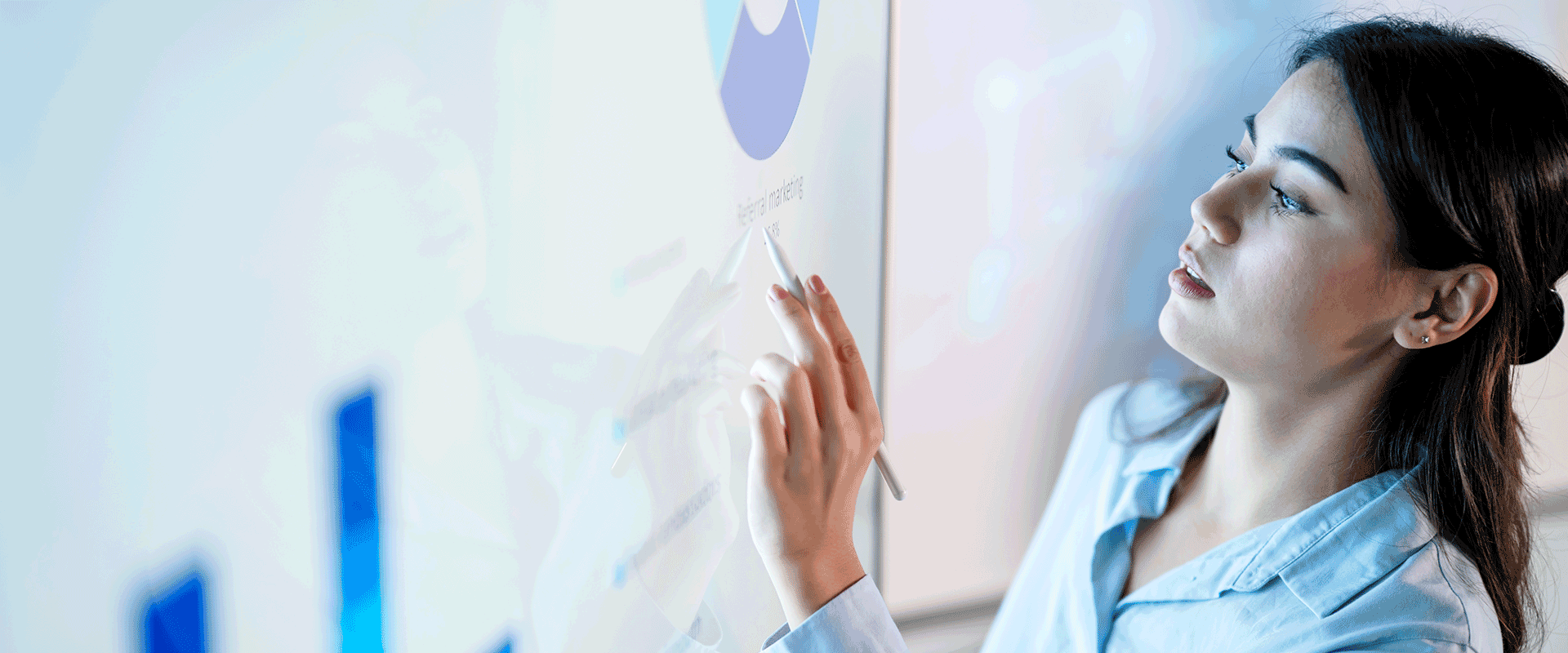 woman writing on board with data