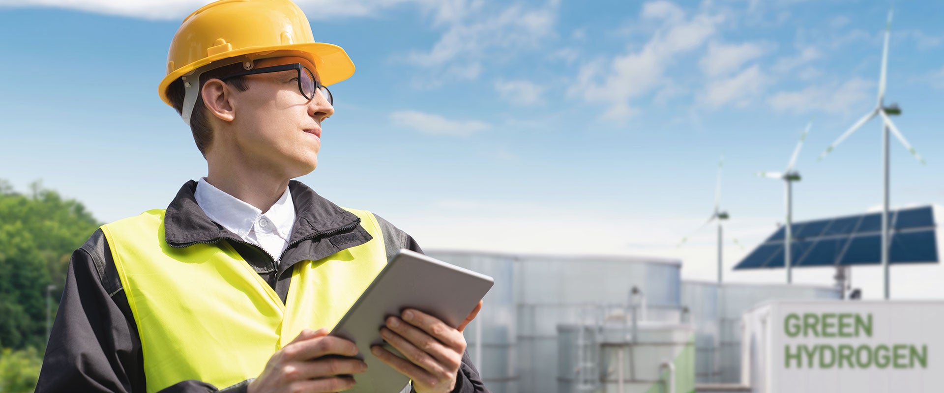 worker next to green hydrogen sign