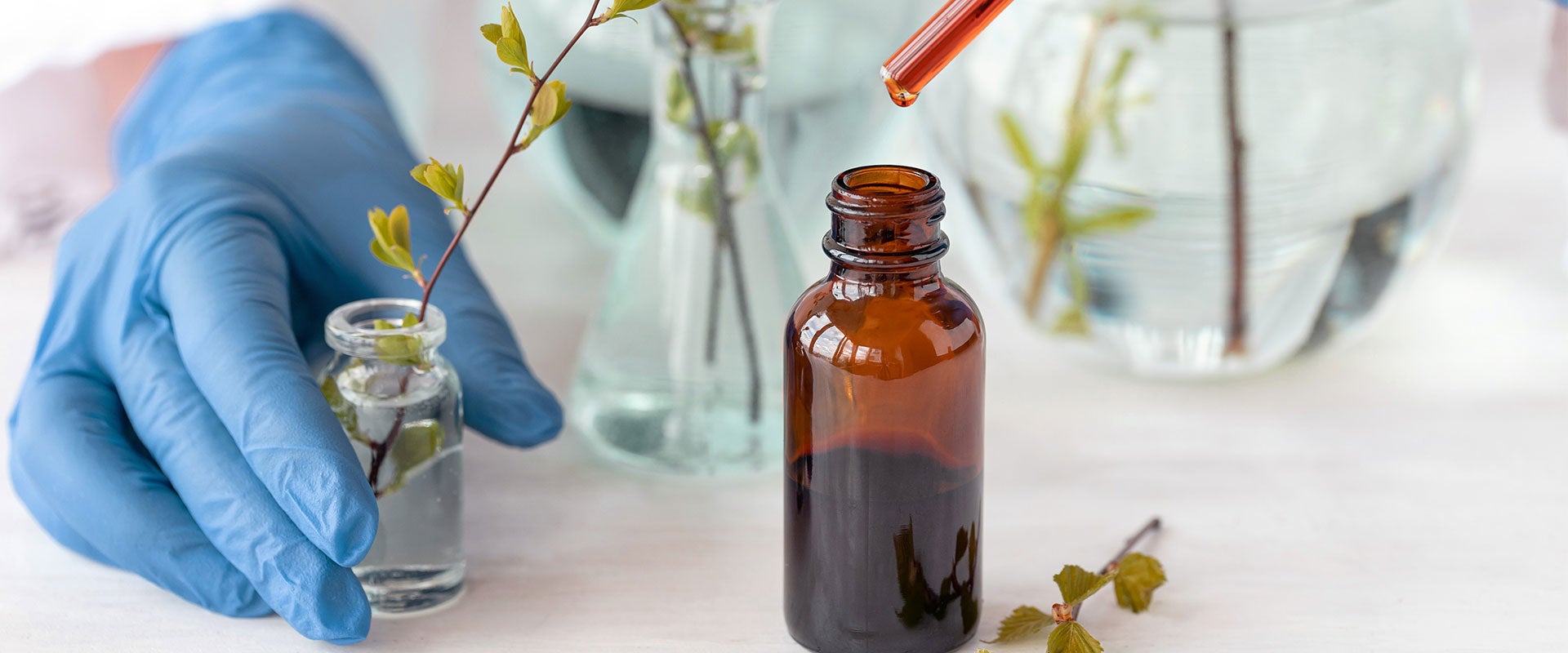 scientist with small bottle and pipette