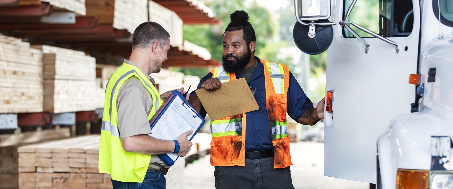 Two logistics workers discussing delivery manifest