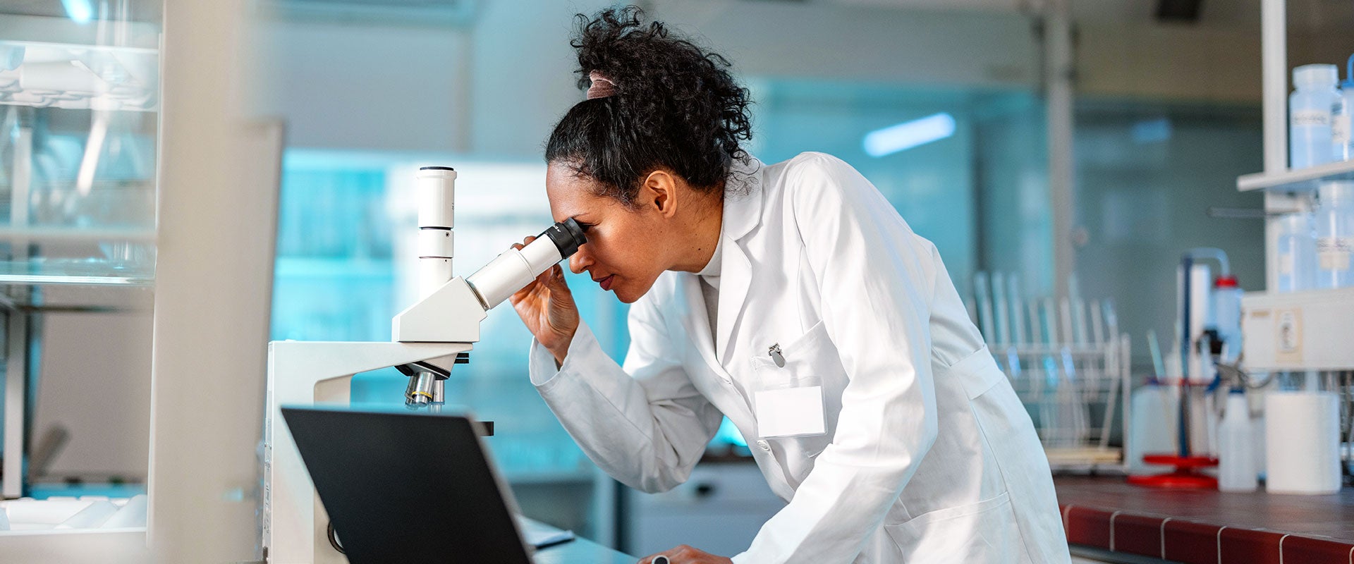 person looking into microscope