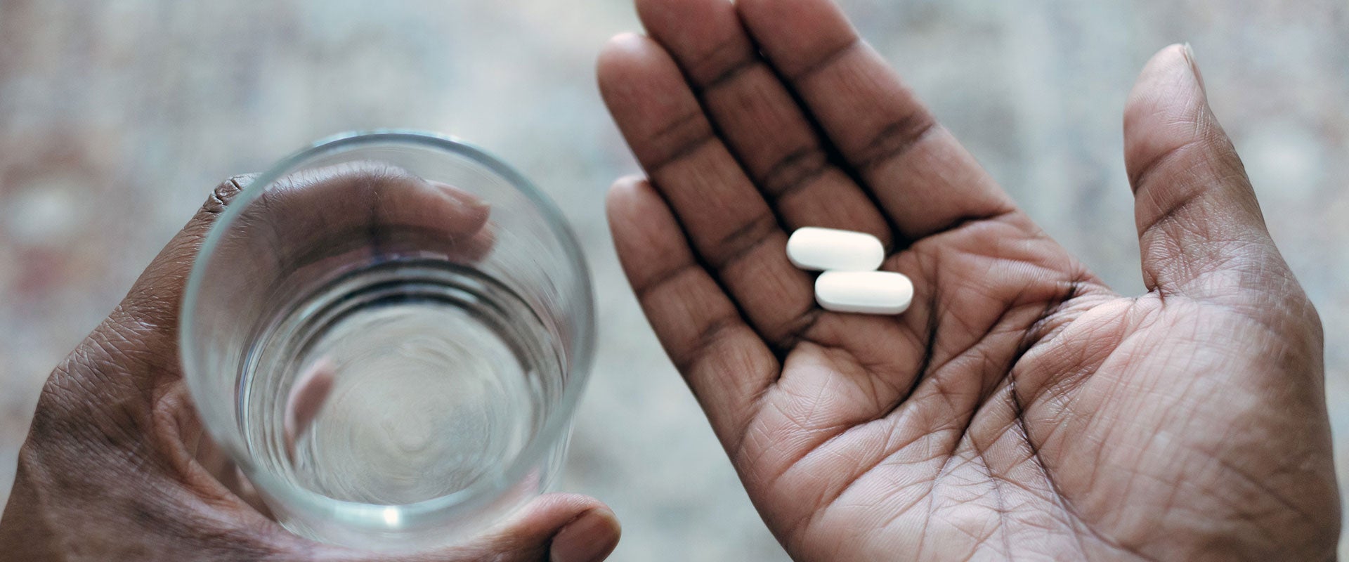 hands holding pills and water