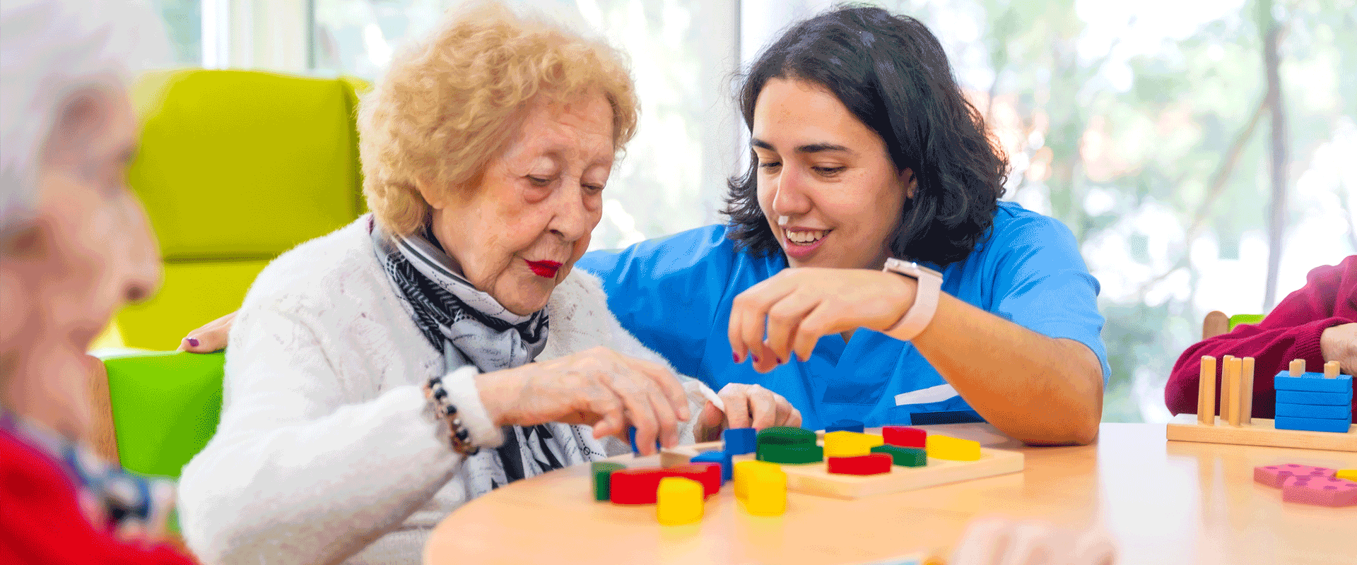 elderly woman with caretaker playing blocks