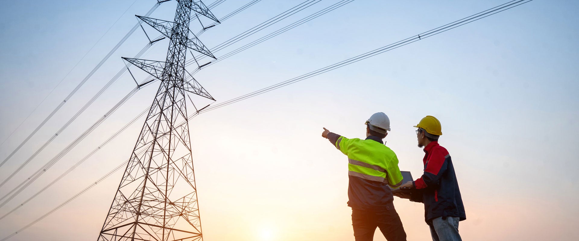 energy workers pointing at transmission tower