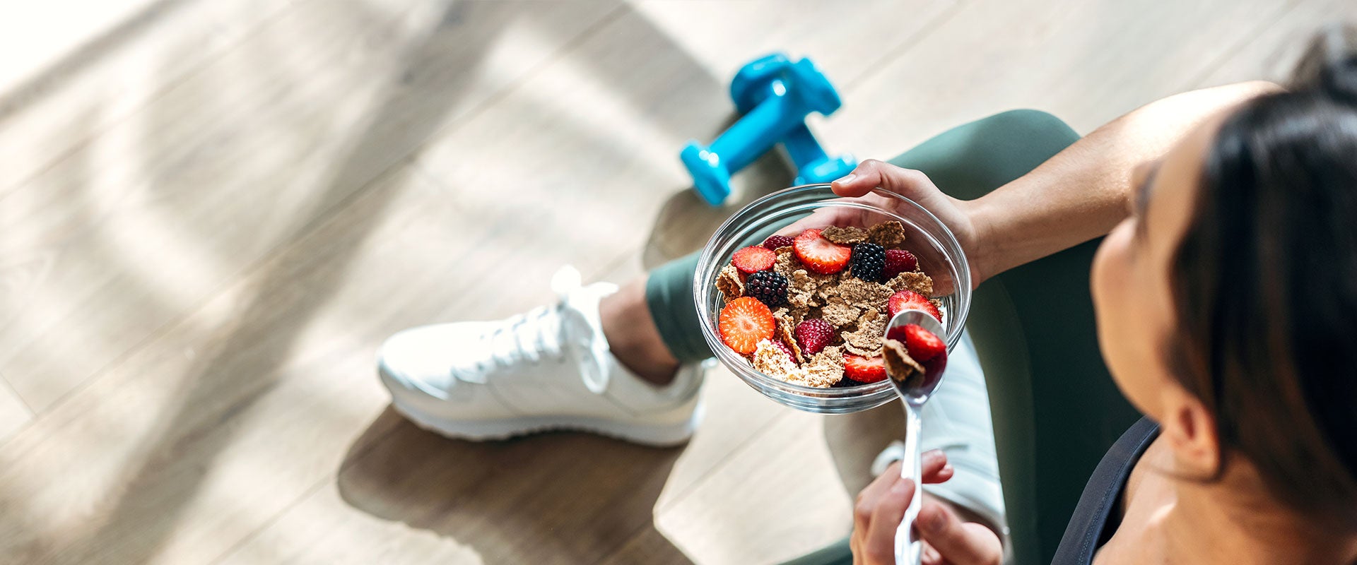 woman eating corn flakes and berries post-workout