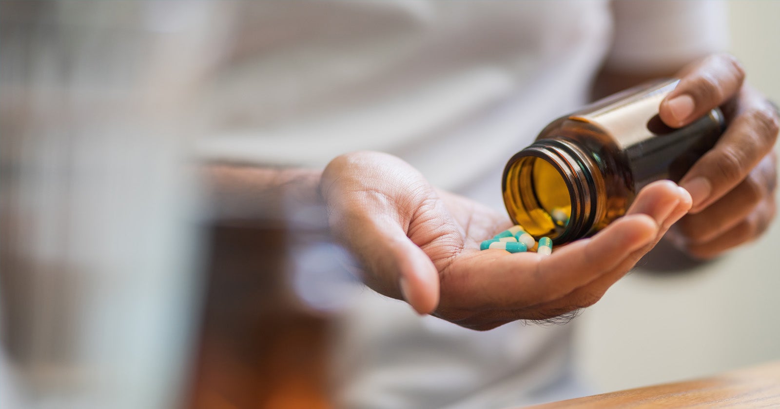 Person pouring pills into hand