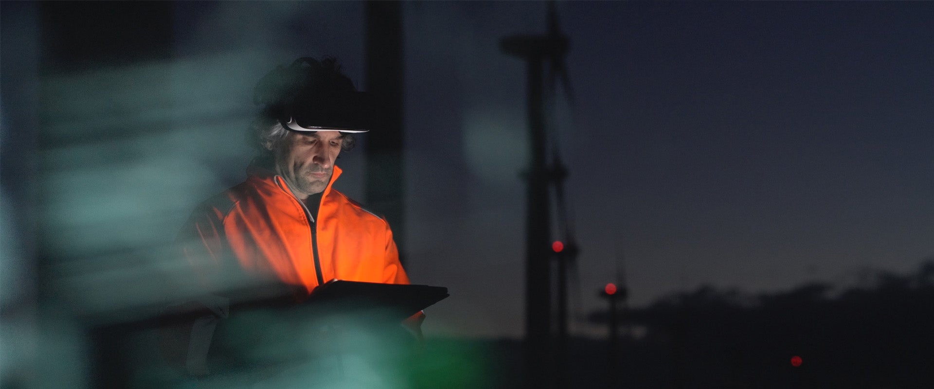Engineer reviewing data on tablet near power lines