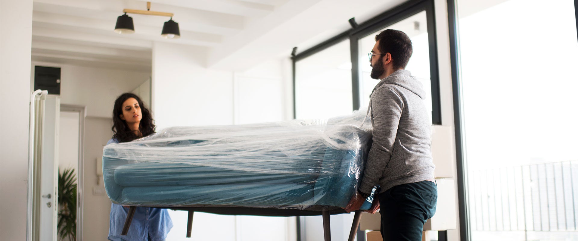 two people carrying mattress