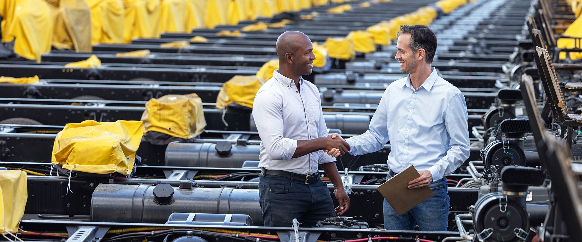 two men shaking hands in factory