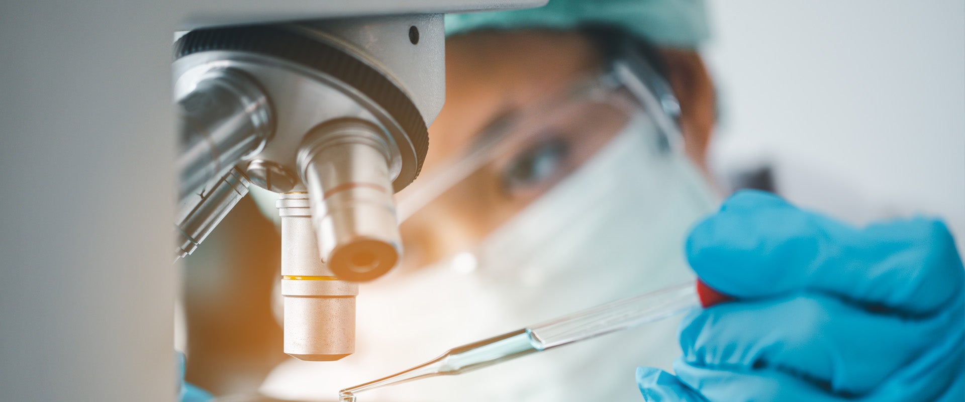 medical researcher analyzing slides on microscope