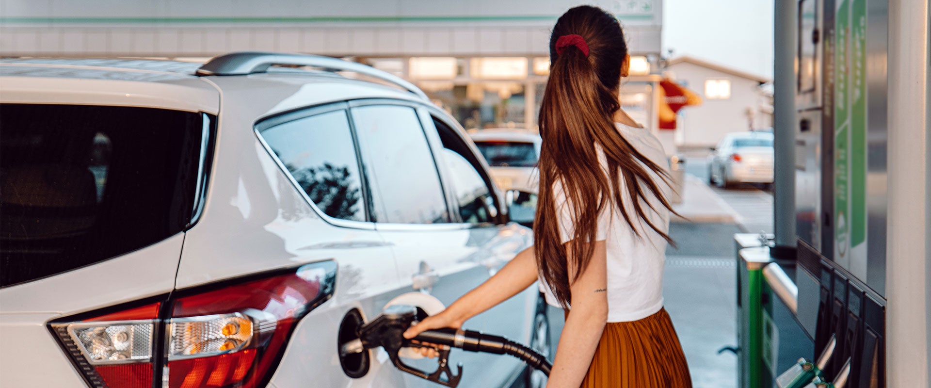 woman pumping gas into car