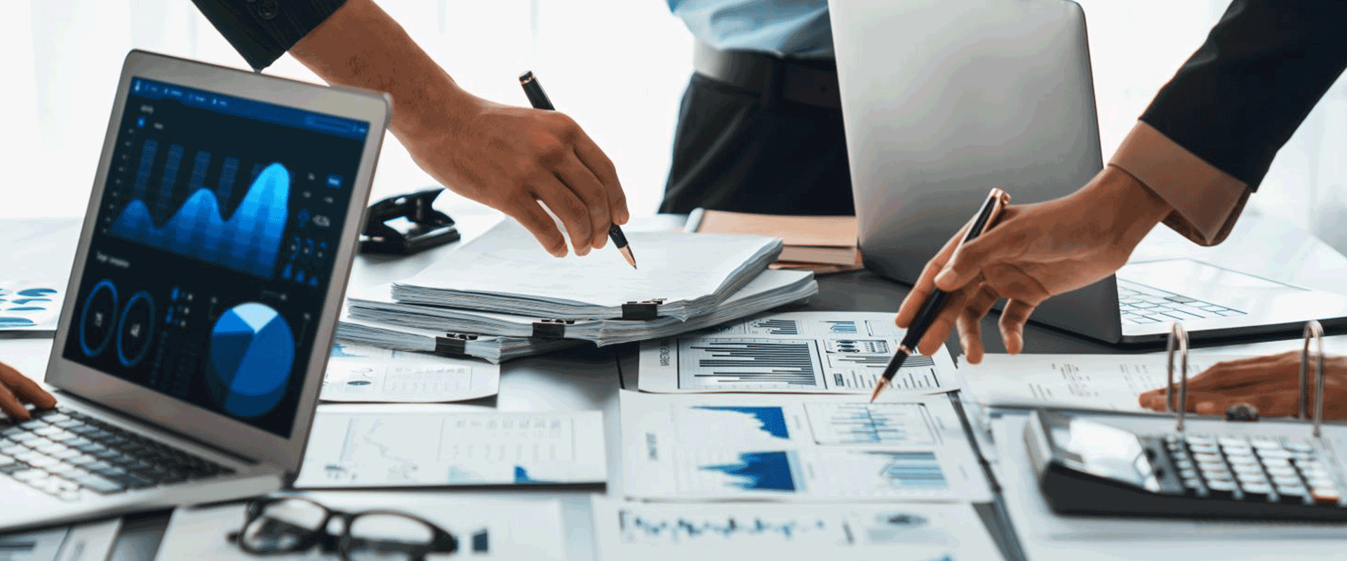 business meeting with people pointing to reports on table
