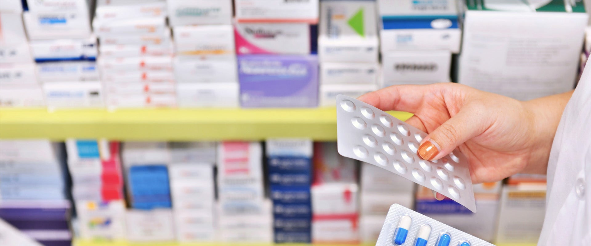 person holding packages of pills