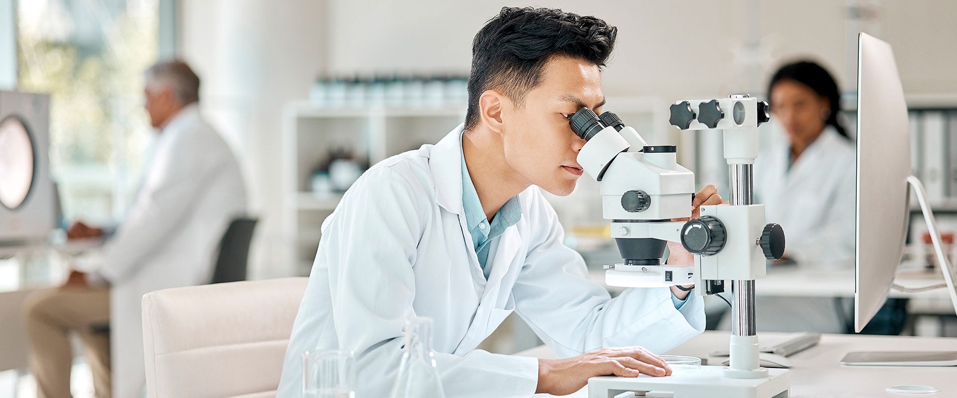 researcher looking into microscope
