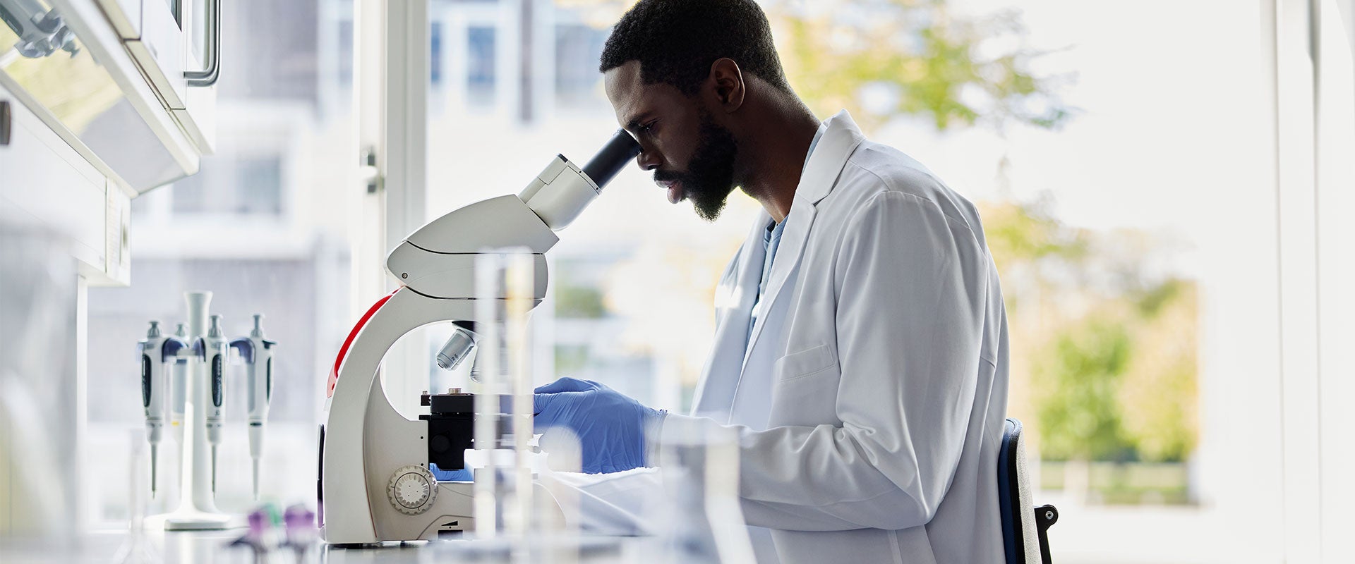 reseracher looking into microscope