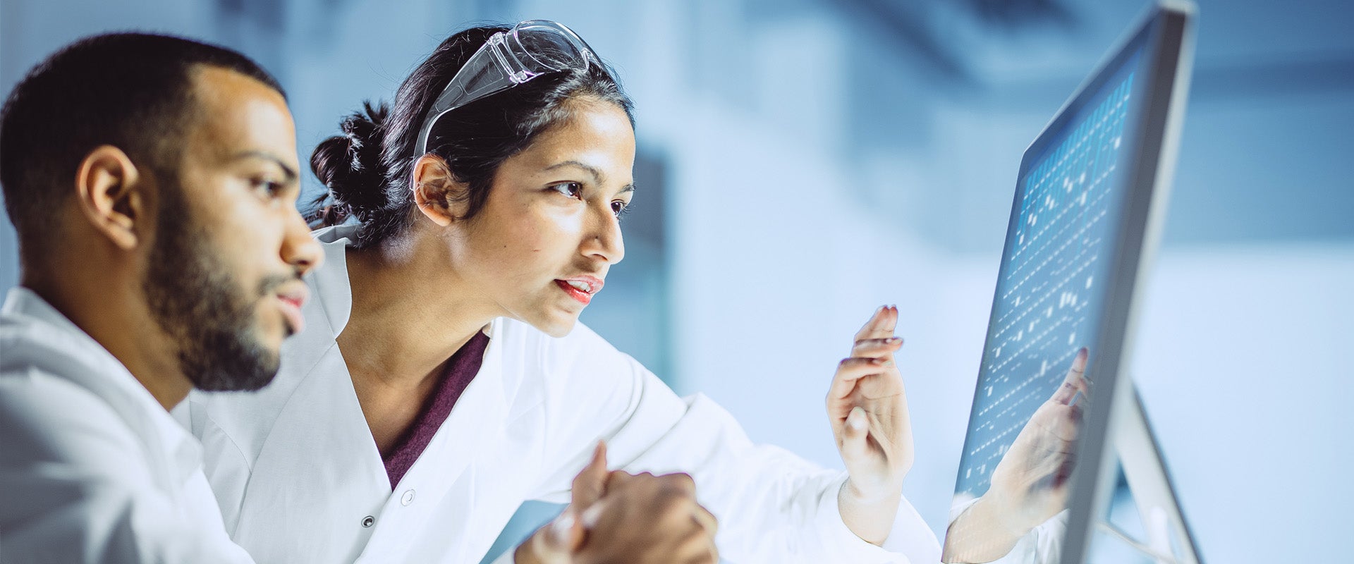 Two researchers looking at monitor
