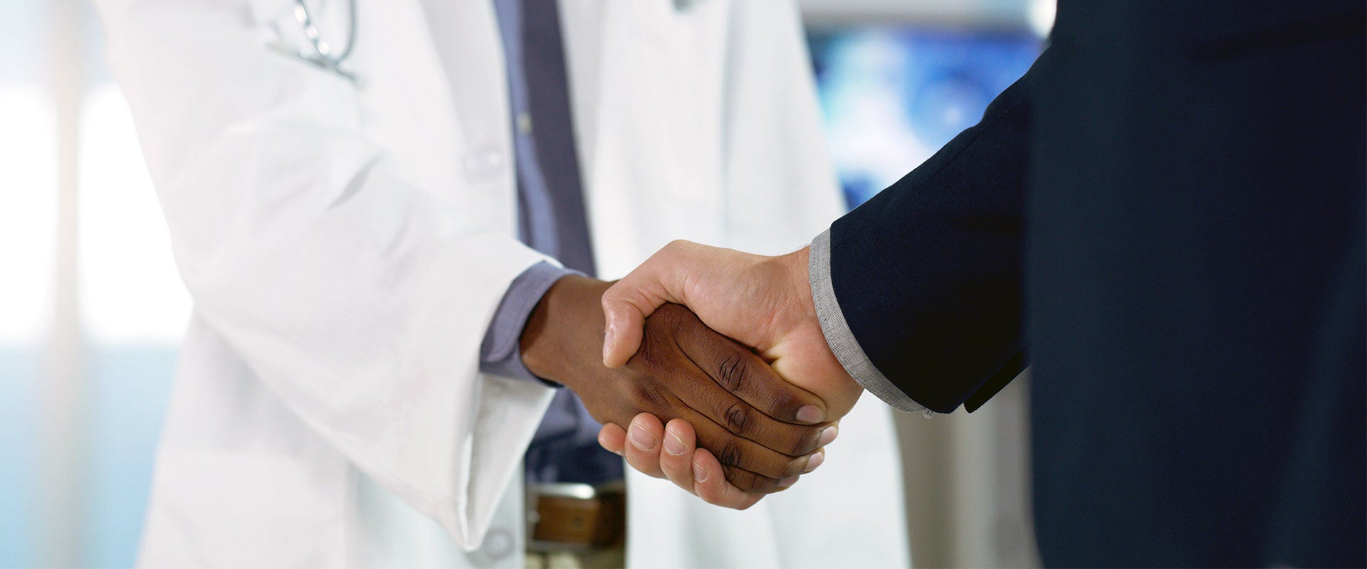 doctor and person in suit shaking hands
