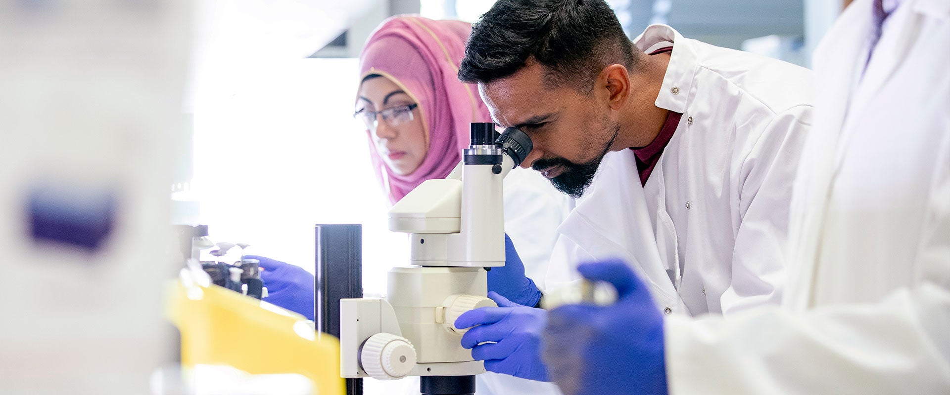 researcher looking into microscope