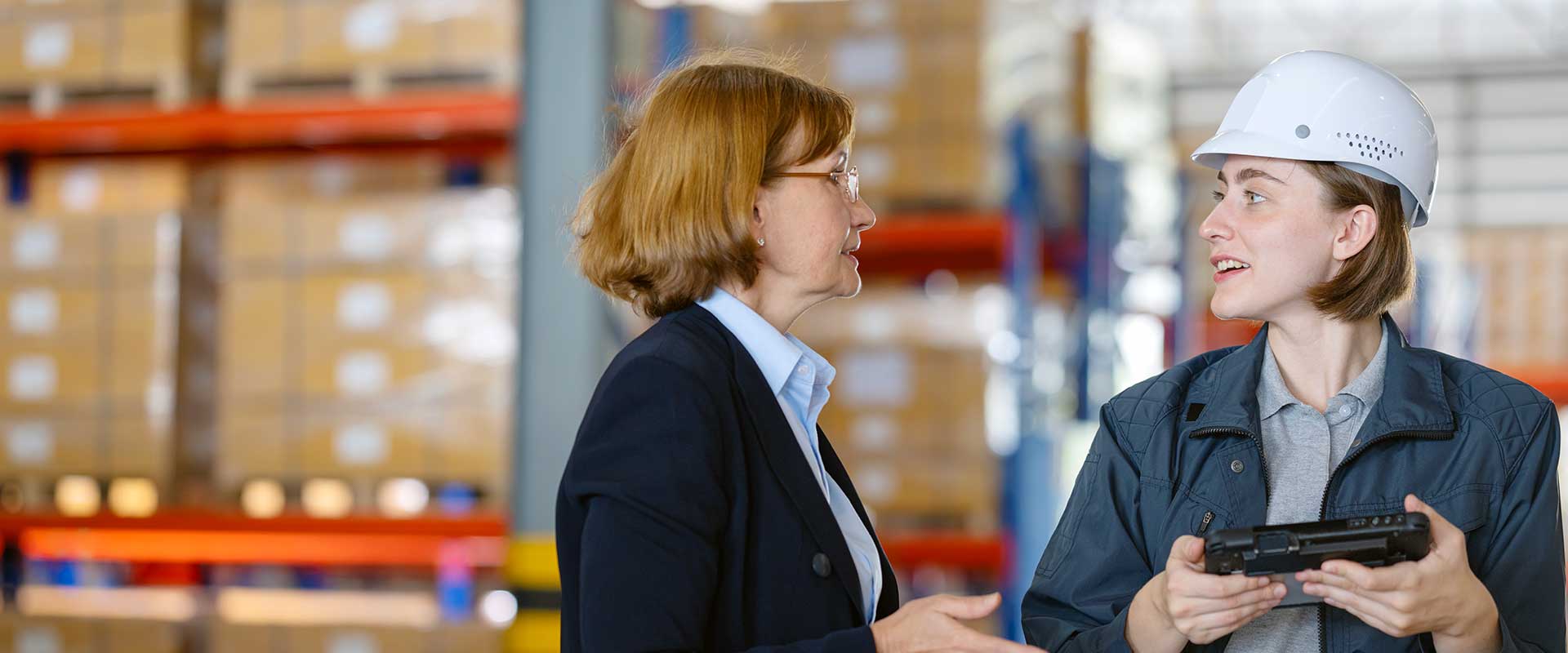 woman in suit talking to woman in hard hat
