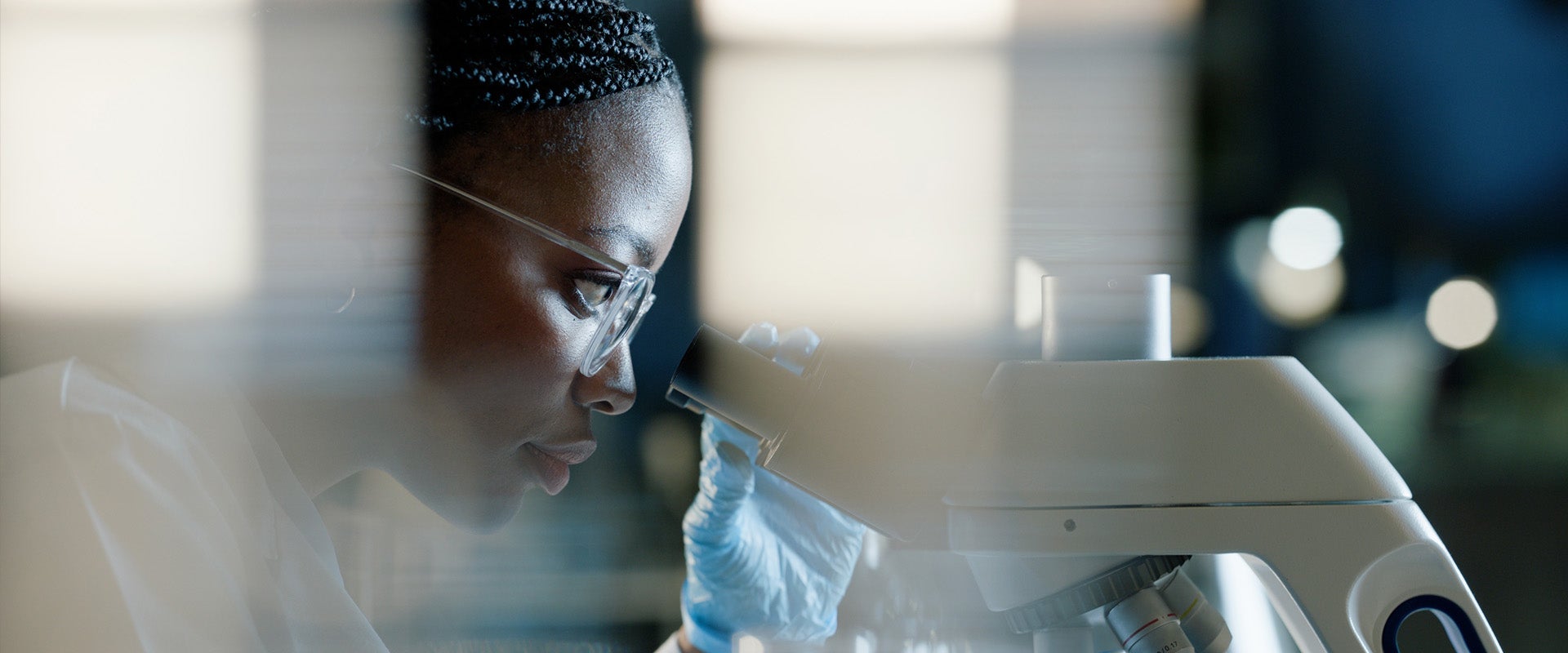 Researcher looking into microscope