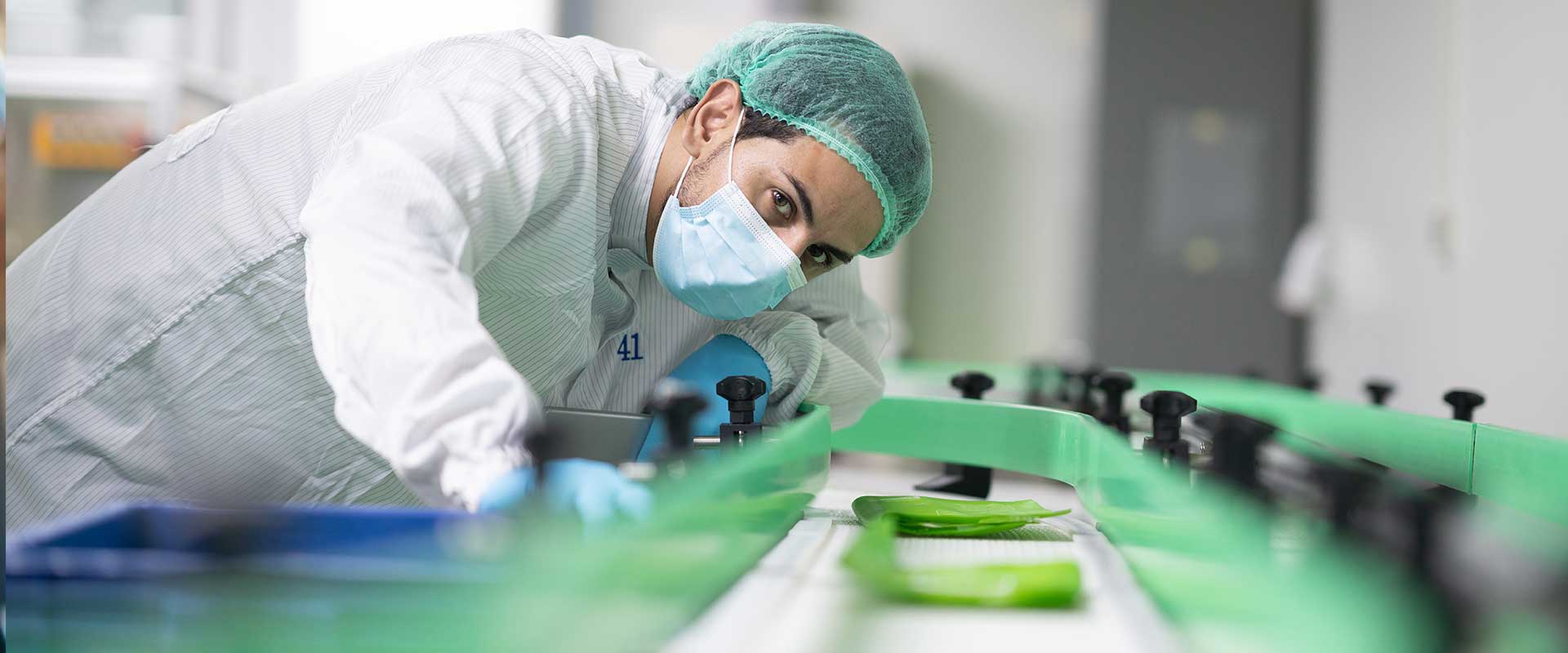 Factory worker looking down conveyor belt