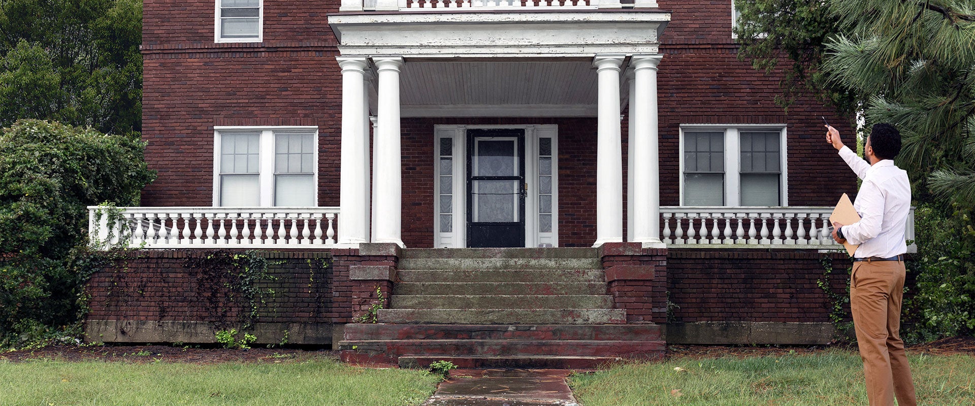 person pointing at house