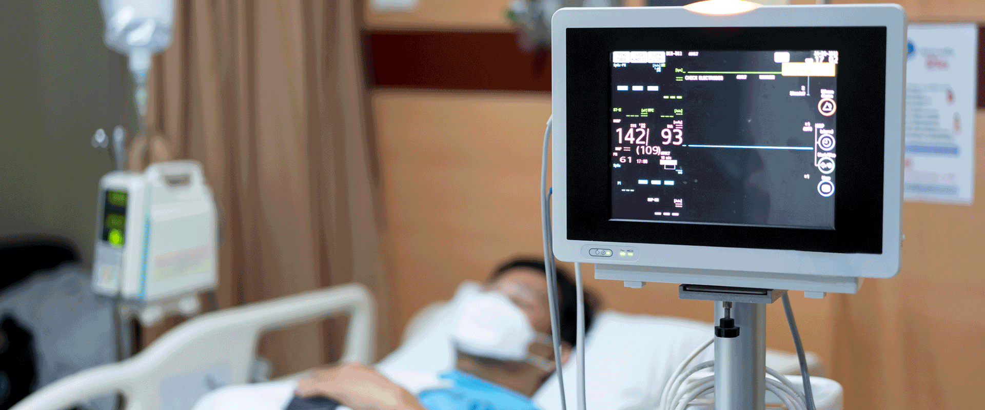 patient in hospital bed with vital signs monitor