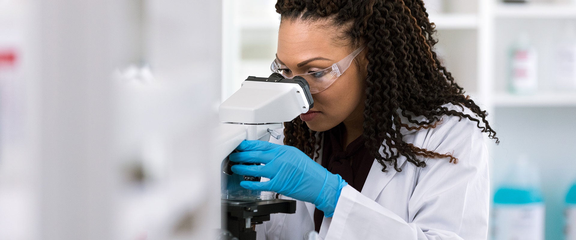 researcher looking into microscope