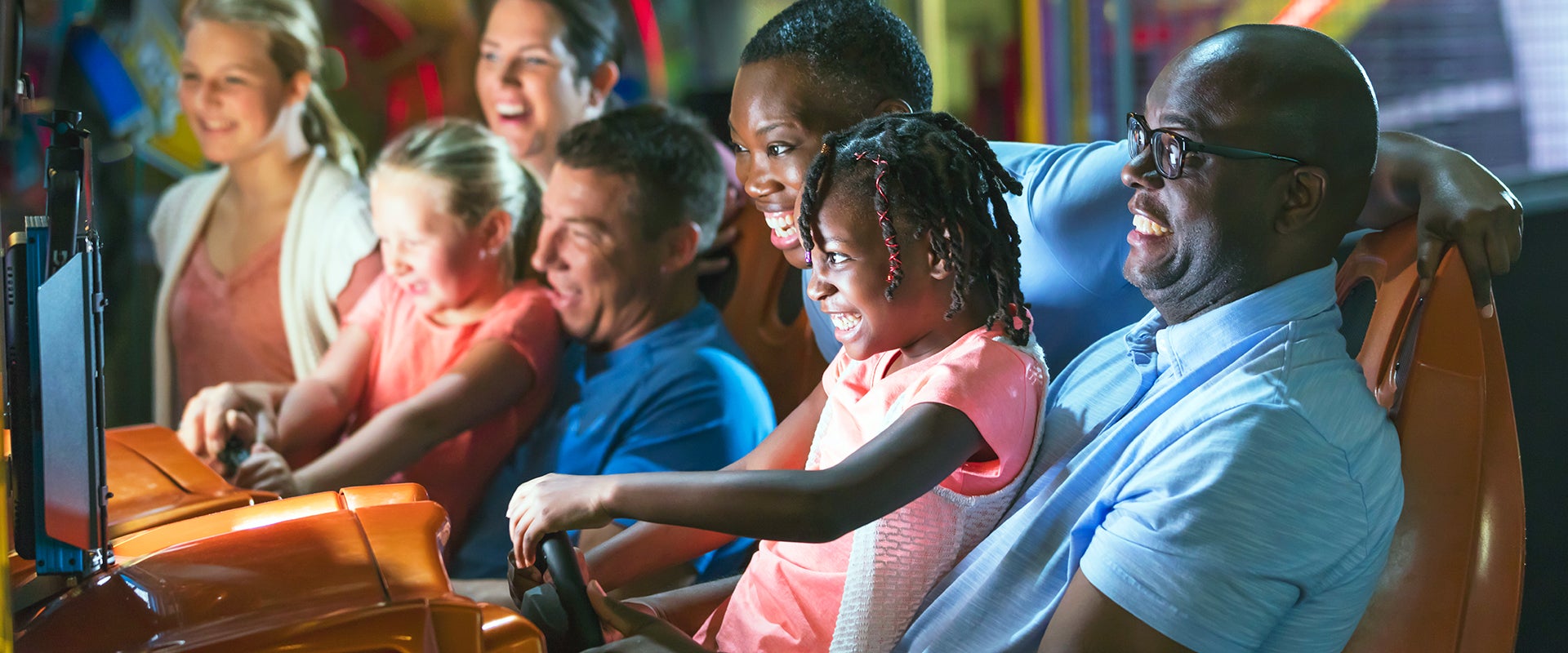 family playing car game at arcade